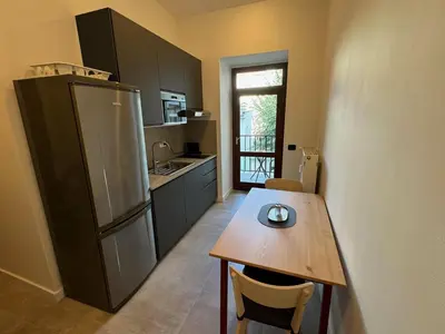 a kitchen with a wooden table and a refrigerator at 1 Bed Flat - Sleeps 2 - Pets - Smoking on terrace in Prague