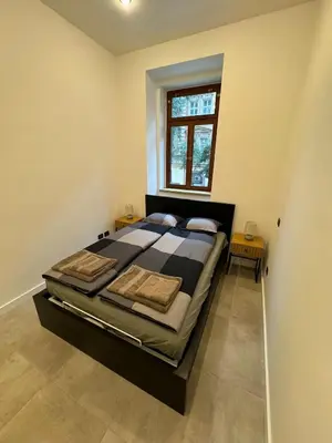 a large bed in a room with a window at 1 Bed Flat - Sleeps 2 - Pets - Smoking on terrace in Prague