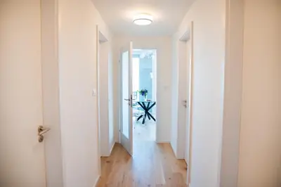 a hallway with white walls and wooden floors at Residence 60 free parking&wifi in Prague