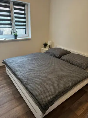 a bed in a white bedroom with a window at Apartmán 1 Jägerhaus in Radovesice