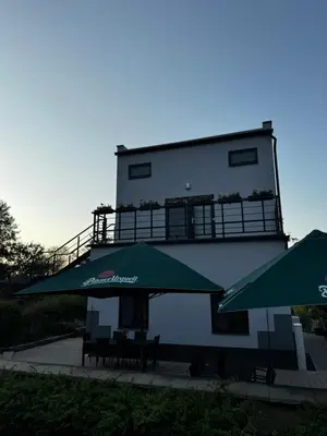 a building with two green umbrellas in front of it at Apartmán 1 Jägerhaus in Radovesice