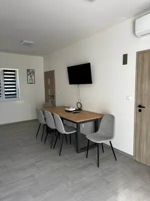 a dining room table with chairs and a television on a wall at Apartmán 1 Jägerhaus in Radovesice