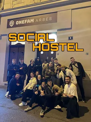 a group of people posing for a picture in front of a sign at Onefam Arbes in Prague