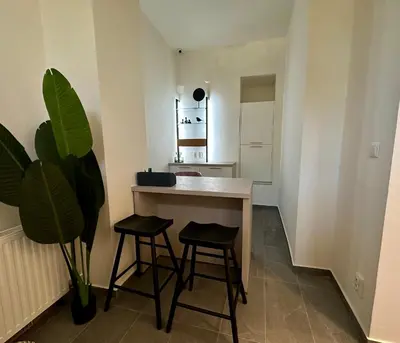 a small kitchen with a table and two stools at Onefam Arbes in Prague