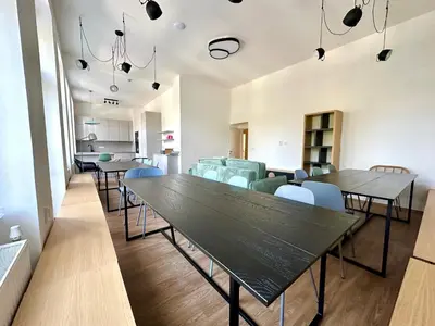 a dining room with tables and chairs and a couch at Onefam Arbes in Prague
