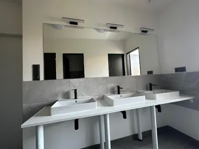 a bathroom with three sinks and a mirror at Onefam Arbes in Prague