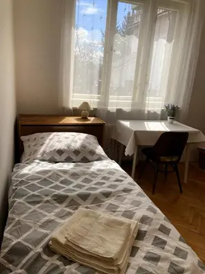 a bedroom with a bed and a table and a window at Spacious apartment - free parking! in Prague