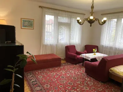a living room with red furniture and a chandelier at Spacious apartment - free parking! in Prague