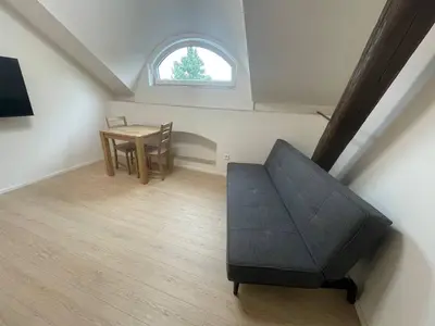 a small bedroom with a bed and a table at Hotel Vinařice Česky kras in Měňany