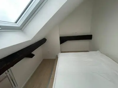 a attic room with a bed and a window at Hotel Vinařice Česky kras in Měňany