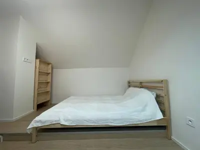 a white room with a bed in the corner at Hotel Vinařice Česky kras in Měňany