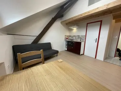 a room with a television and a kitchen with a ladder at Hotel Vinařice Česky kras in Měňany