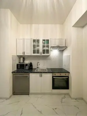 a kitchen with white cabinets and a sink at Powder Tower Residence in Prague