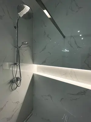 a shower in a bathroom with white marble walls at Powder Tower Residence in Prague
