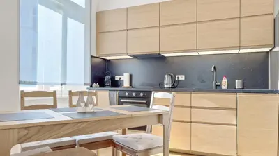 a kitchen with wooden cabinets and a table and chairs at Nebeský apartmán in Prague