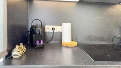 a counter with a roll of paper towels and a phone at Nebeský apartmán in Prague
