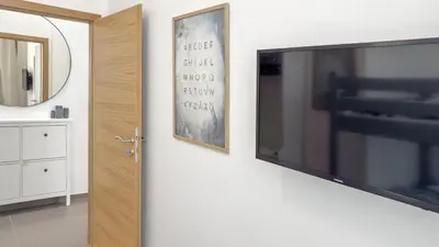 a flat screen tv hanging on a wall next to a mirror at Nebeský apartmán in Prague