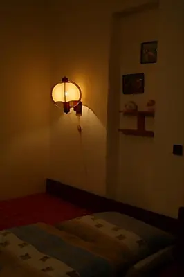 a bedroom with a light on the wall and a bed at Apartment Trojska in Prague