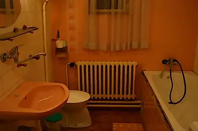 a bathroom with a toilet and a sink and a radiator at Apartment Trojska in Prague