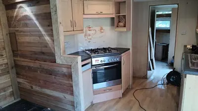 a kitchen with a stove in a tiny house at Pobřežní chatička Marta in Sázava
