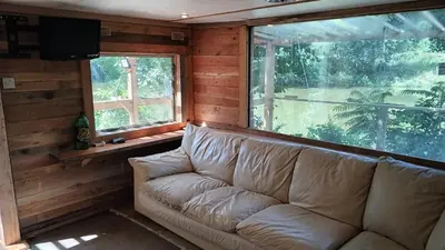 a couch sitting in a room with two windows at Pobřežní chatička Marta in Sázava