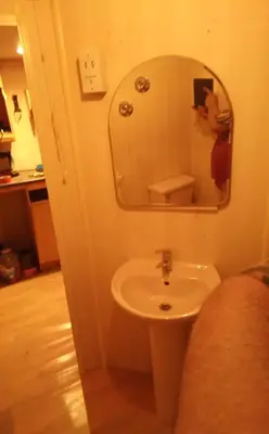 a person taking a picture of a bathroom with a sink at Pobřežní chatička Marta in Sázava