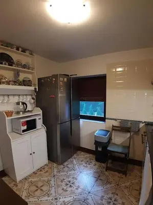 a kitchen with white cabinets and a table in it at Cottage Nova in Živohošť