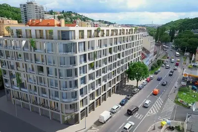 a large white building on a city street with cars at Spacious Top Floor Flat, Air Conditioning, Free Parking, 200Mb WiFi in Prague