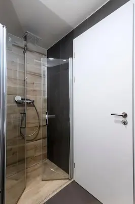 a shower with a glass door in a bathroom at Spacious Top Floor Flat, Air Conditioning, Free Parking, 200Mb WiFi in Prague