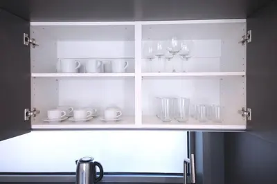 a kitchen cupboard with glasses and dishes in it at Spacious Top Floor Flat, Air Conditioning, Free Parking, 200Mb WiFi in Prague