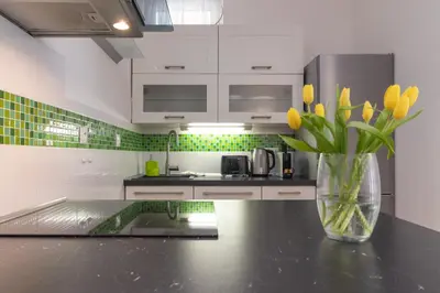 a kitchen with a vase of yellow flowers on a counter at Peace and Comfort Near Center with Balcony, 500MB WIFI in Prague