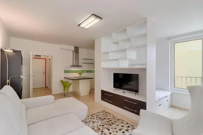 a living room with white furniture and a flat screen tv at Peace and Comfort Near Center with Balcony, 500MB WIFI in Prague