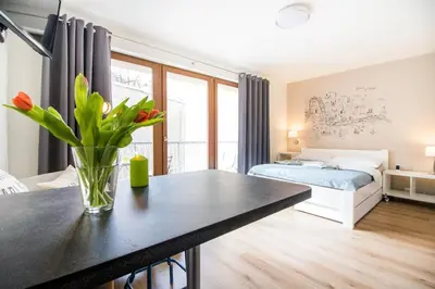 a bedroom with a table with a vase of flowers at Stylish Studio with Balcony, 12 Min to City Centre, Free Netflix & WiFi in Prague