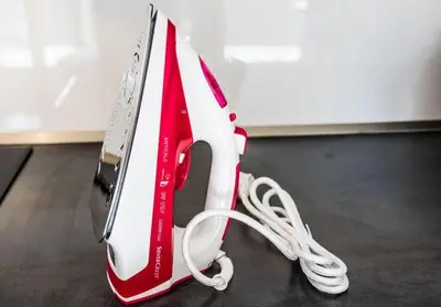 a red and white appliance sitting on the floor at Stylish Studio with Balcony, 12 Min to City Centre, Free Netflix & WiFi in Prague