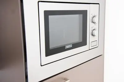 a microwave on a wall with a picture on it at Stylish Studio with Balcony, 12 Min to City Centre, Free Netflix & WiFi in Prague