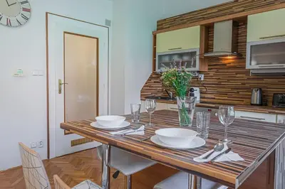a wooden table with plates and glasses on it in a kitchen at Josef Manes birth house, All Sights Walkable, Old Town Square in Prague