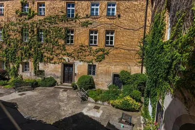 a large brick building with benches in front of it at Josef Manes birth house, All Sights Walkable, Old Town Square in Prague
