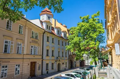 a building with a clock tower on top of a street at Josef Manes birth house, All Sights Walkable, Old Town Square in Prague