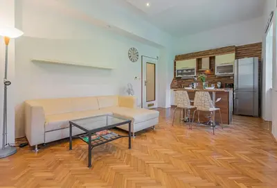 a living room with a couch and a table and a kitchen at Josef Manes birth house, All Sights Walkable, Old Town Square in Prague
