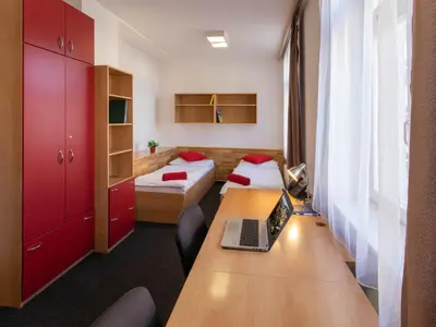 a room with a desk and a laptop on a table at Masarykova Kolej in Prague