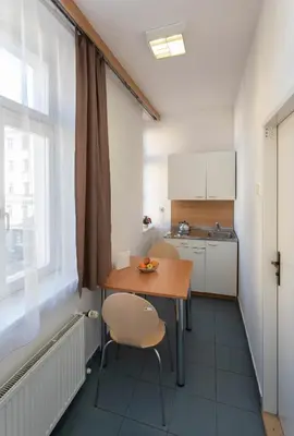 a small kitchen with a table and chairs in a room at Masarykova Kolej in Prague
