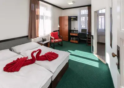a hotel room with a bed with red ribbons on it at Masarykova Kolej in Prague