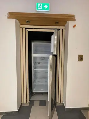 an empty refrigerator with its door open in a hallway at Trung Lo Cao in Prague
