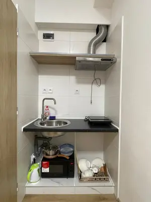 a small kitchen with a sink and a counter at Trung Lo Cao in Prague