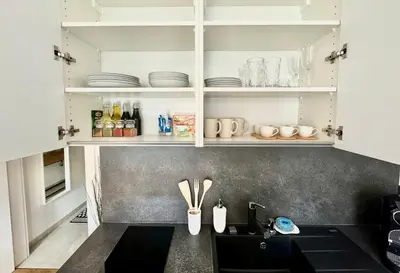a kitchen with white cabinets and a counter with utensils at ESMOA apartments - Ovenecká, Praha 7 - plně vybaven in Prague