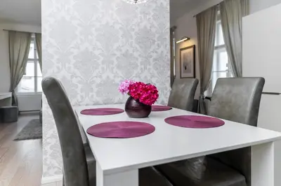 a white table with purple plates and a vase of flowers at Royal Residence Vysehrad Prague in Prague