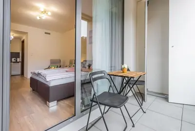a bedroom with a bed and a table and chairs at Flat with Bathtub & Balcony, only 12min Centrum, 200Mb WIFI in Prague
