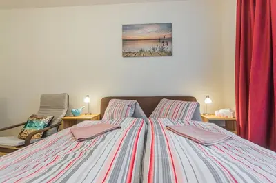 a bedroom with a large bed with red curtains at Flat with Bathtub & Balcony, only 12min Centrum, 200Mb WIFI in Prague
