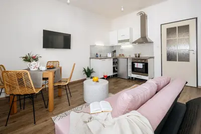 a living room with a pink couch and a table at Prague Days - Open-plan Studio Near Vyšehrad Castle in Prague