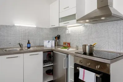a kitchen with white cabinets and a sink at Prague Days - Open-plan Studio Near Vyšehrad Castle in Prague